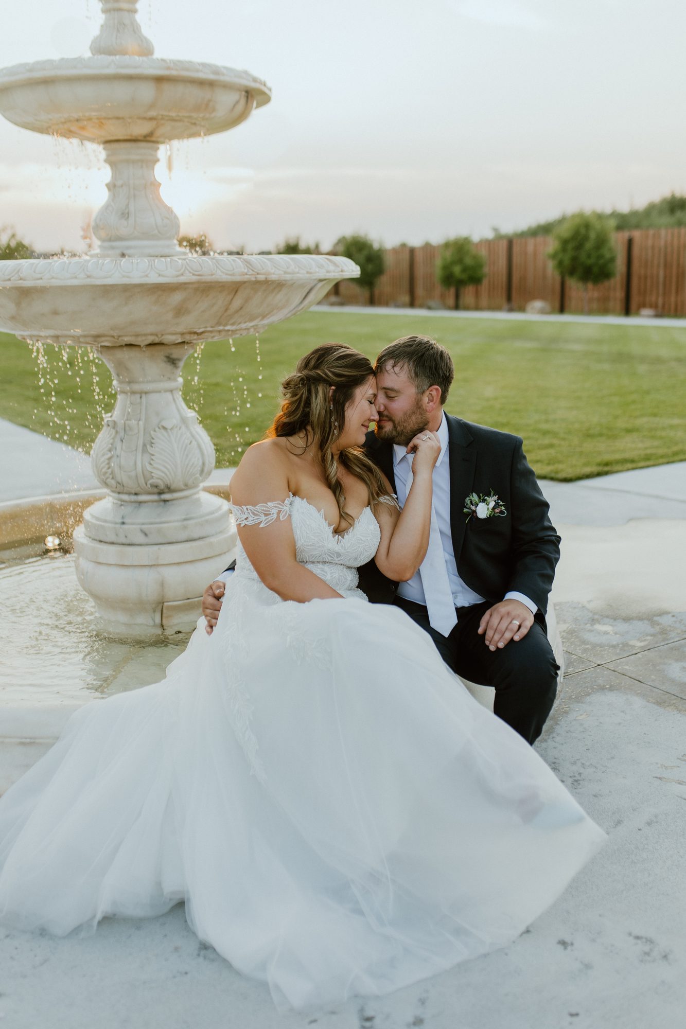 Newlyweds seated at the courtyard fountain